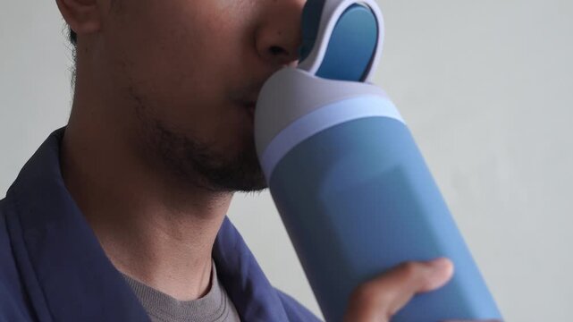 Close Up man drinking water bottle after workout training