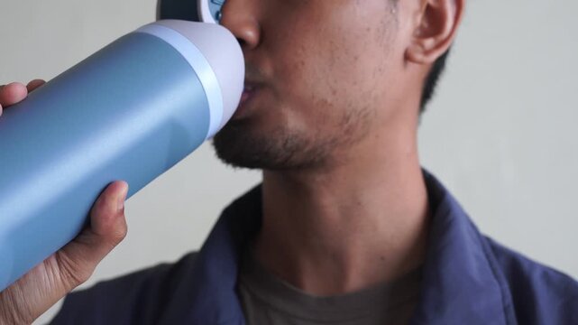 Close Up man drinking water bottle after workout training