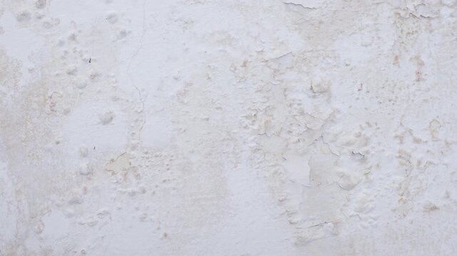 Peeling, cracked and flaking paint on concrete wall
