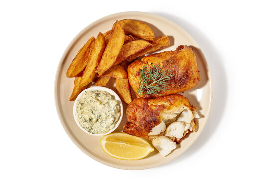 Golden fish with side dish. Breaded fish accompanied by golden potato wedges and tartar sauce