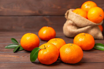 Fresh, ripe, juicy tangerines on the table. Whole and halved tangerines, clementines with green leaves. Citrus fruits. Tangerine or clementine. Fresh oranges. Vitamin C. Natural vitamin. Orange. Space