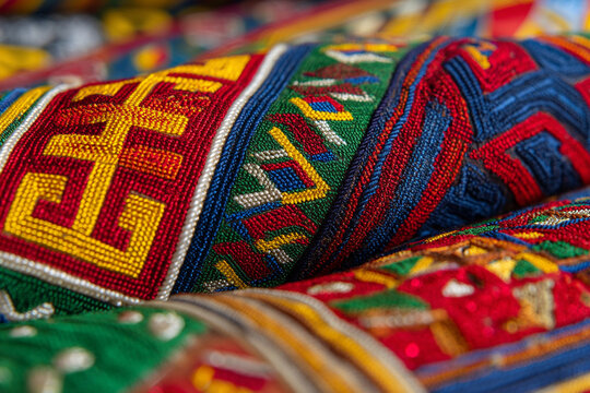 A close-up of colorful traditional Equatorial Guinean fabrics, intricate patterns and rich embroidery, highlighting vibrant textile heritage.