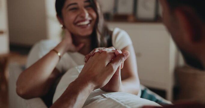 Happy couple, holding hands and relax on couch with love, support and connection for Valentines Day. People, conversation and smile in home with affection, trust and bonding for marriage commitment.