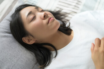 ベッドで眠る日本人女性の寝顔