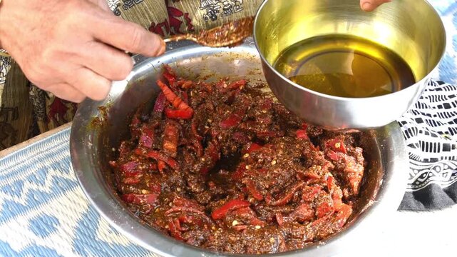 putting mustard oil in red chilli pickle, it is a natural preservative  of storing pickle for longer time.  