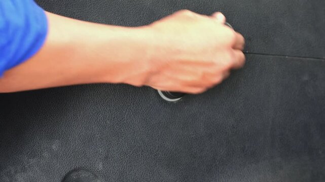 Hand crank, non-electric, manual car window in a dove grey color an old vehicle.