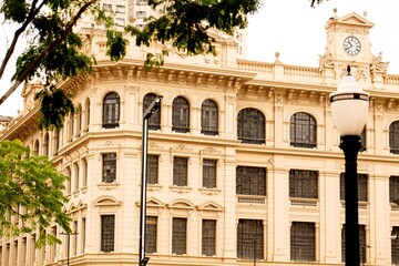 Fototapeta premium Fachada de prédio com janelas em forma de arco e poste de rua. 