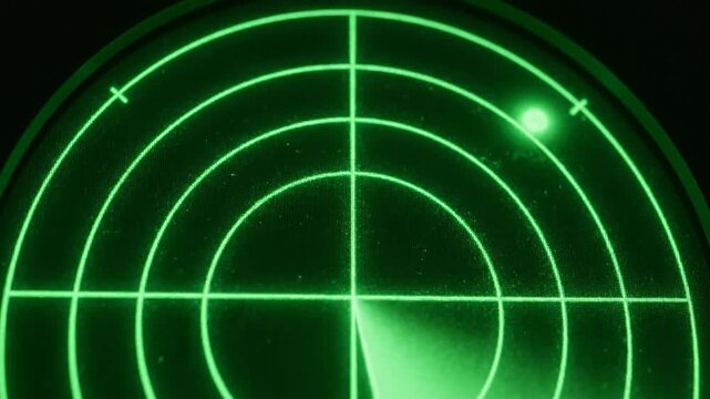 Glowing green radar screen scan display with moving sweep and signal blip