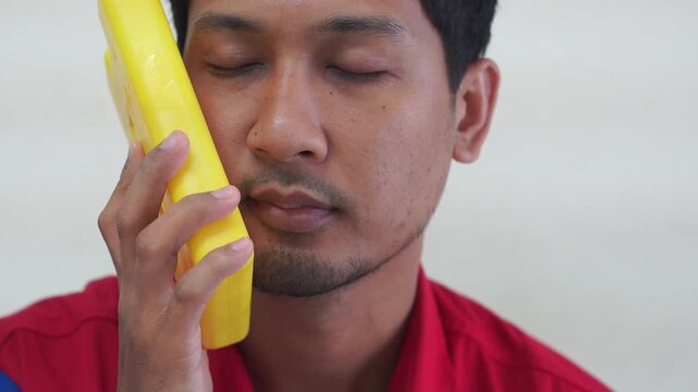 sad man holding ice pack on her head