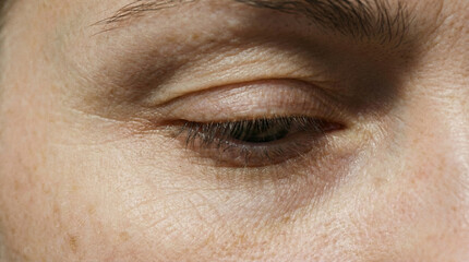 Obraz premium Macro shot of a human eye and skin texture with natural freckles and aging lines