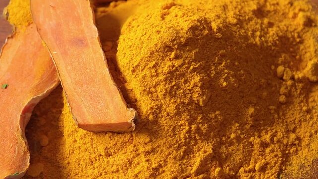 Turmeric powder and turmeric rhizomes in a bowl