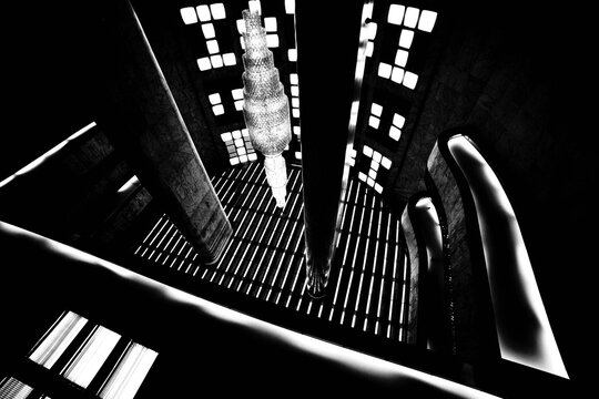 Interior de pr&eacute;dio com teto alto, colunas de m&aacute;rmore, janelas e fretas em forma geom&eacute;tricas em preto e branco. 