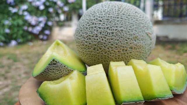 Cantaloupe melon slices on wood background
