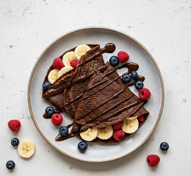 Delicious chocolate crepes with fresh berries and banana