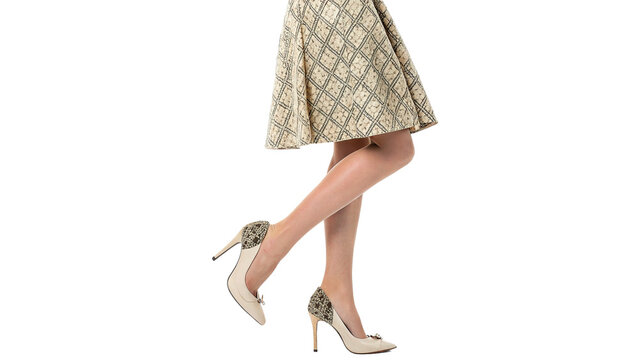 Woman wearing stylish shoes with a patterned dress while posing with one leg raised isolated on transparent background