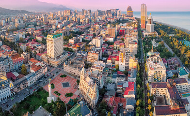 Aerial view capturing the Batumi skyline and Europe Square at golden hour, with the Black Sea coastline in the background