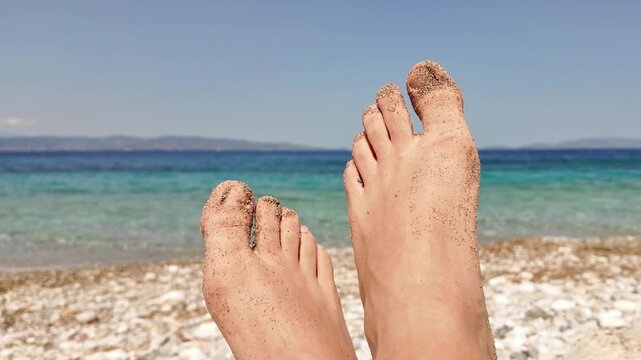 Man sunbathing on a rocky sea ocean beach.
