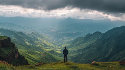 Obraz premium Man with his back turned on the top of a mountain