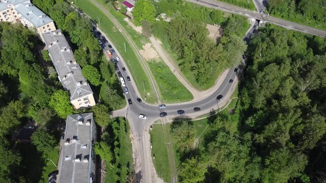 Aerial view of a city traffic jam, cars queuing at a narrow road bottleneck under a railway tunnel. Urban congestion from above