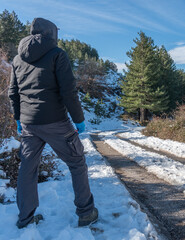 Man Seen from Behind Standing on Snowy Mountain Road