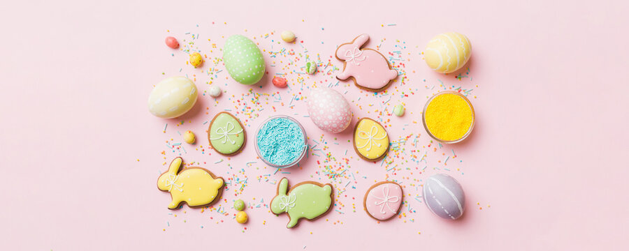 holiday preparation Multi colors Easter eggs with cookies on colored background . Pastel color Easter eggs. holiday concept with copy space
