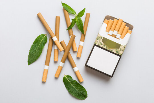 Pack of menthol cigarettes and fresh mint on colored table, Menthol cigarettes top view flat lay