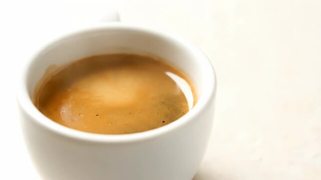 Dark roasted coffee beans fill a pristine white cup. The beans magically transform into a rich, steaming espresso.