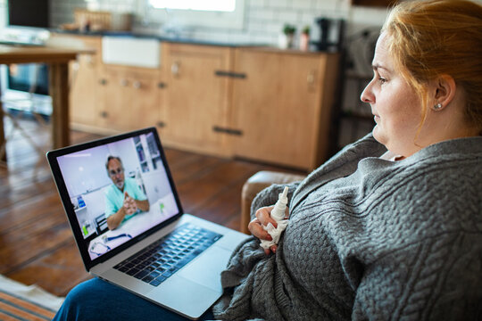 Woman on telehealth video consultation with doctor at home