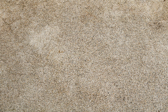 A fine aggregate wash or pebble dash surface. The texture is composed of a dense, uniform layer of tiny, multicolored pebbles and grains embedded in a light-colored base.