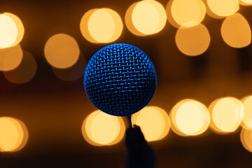 Fototapeta premium Professional Vocal Microphone with Blue Lighting on Warm Golden Bokeh Background