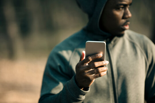 Man checking smartphone during outdoor workout in park