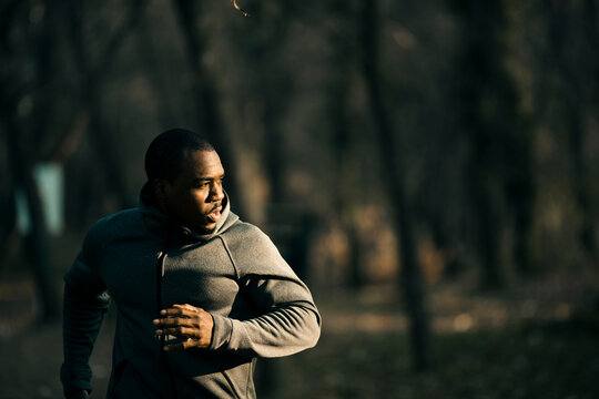 Man jogging on forest trail at dawn
