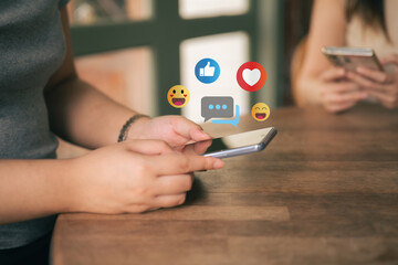 A woman is playing on her mobile phone. The concept of social media includes chatting with friends online and sending reaction icons through the application.