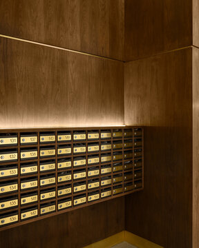 Elegant row of golden postal mailboxes in wooden wall