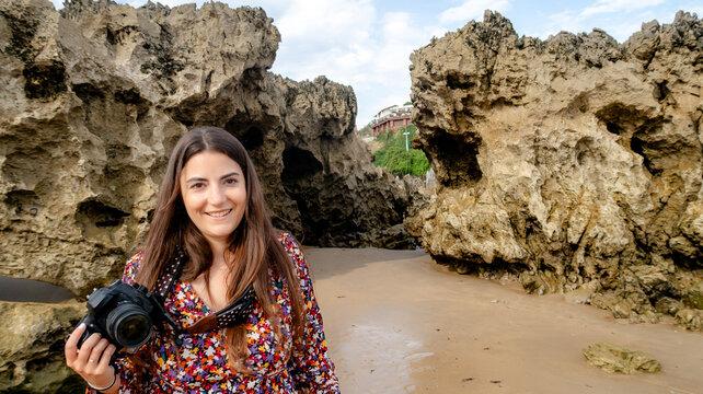 Woman holding camera at Toro Beach, Llanes, Asturias