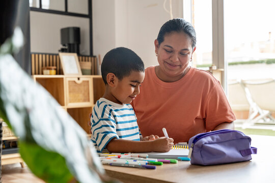Mother and son coloring together at home