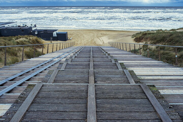 Fototapeta premium Steps down to Egmond aan Zee beach during a choppy North Sea.