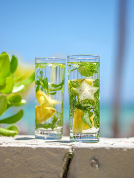 Tropical refreshing drinks with star fruit and mint on beach