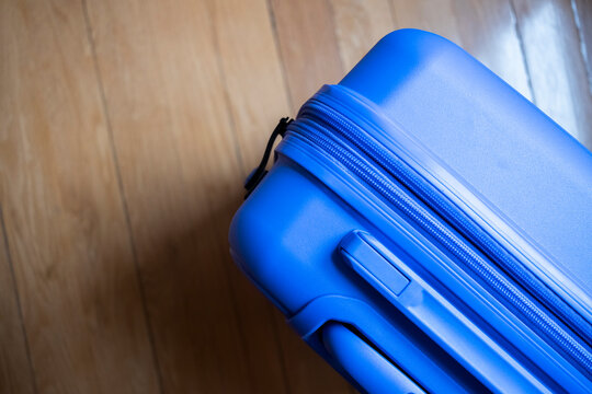 Blue suitcase on wooden floor