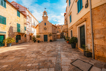 Fototapeta premium Jelsa town on Hvar island, with traditional Dalmatian stone architecture and boats moored in the harbor, Croatia.