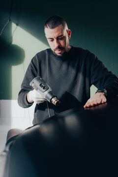 Skilled worker applying vinyl wrap to a vehicle
