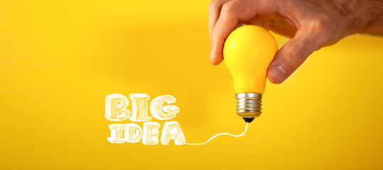 Big idea concept with lightbulb on yellow background, copy space