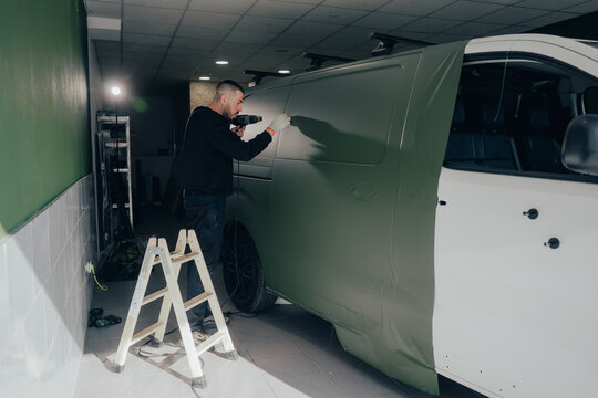 Skilled worker in automotive vinyl wrapping process