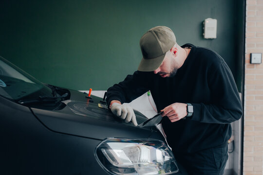 Vehicle customization and vinyl wrapping process in workshop