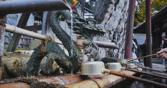 Ladles set upside down on old Japanese fountain - closeup shot