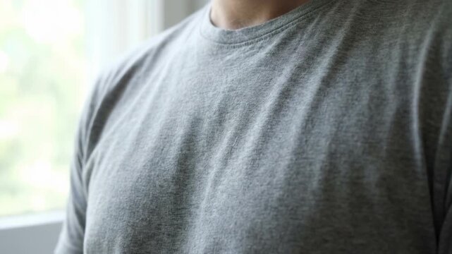 Close-up shot of a person in a gray t-shirt, showing subtle textures, soft lighting, and a casual aesthetic.