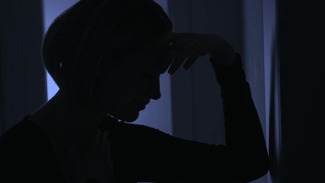 Black silhouette upset unhappy woman cries after quarrel scandal in dark room, mood anxiety depression emotion. Sad lonely girl cry feels bad head ache panic attack stress, suffers pain hurt abuse woe