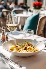 Fresh pasta with ricotta served in white bowl on linen tablecloth, wine glass beside. Refined restaurant atmosphere with subtle light and soft focus.