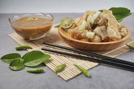 Batagor or baso Tahu Goreng. Indonesian Traditional Street Food Fried Dumpling Made from Fish with Tapioca Flour, Tofu, and Dumpling Wrapper. Served with Spicy Peanut Sauce, Sweet Soy Sauce, and Lime 
