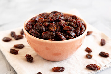 Fototapeta premium Organic Dried Chilean Dark Raisins in a Bowl, side view. Copy space.